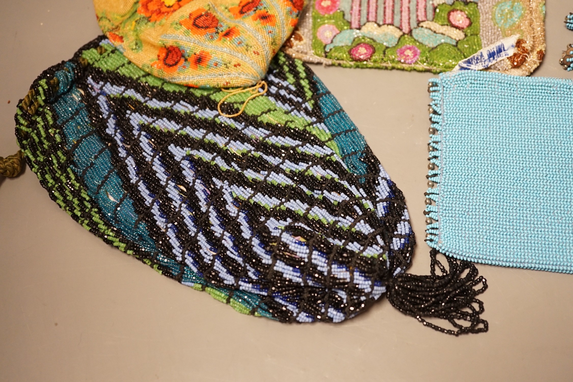 A late 19th century floral bead worked drawstring bag, a later jazz age beaded bag, a turquoise plain bead bag with zip and an unlined bead bag with a classical scene, (4)